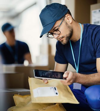 Delivery man cross checking the order details on the package and the delivery management system