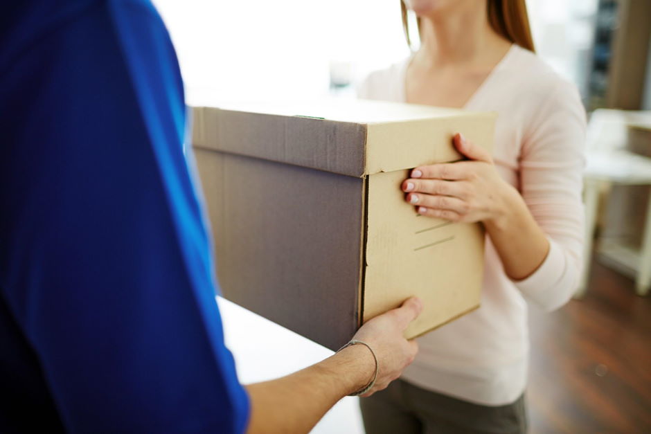 Woman receiving a delivery box from a delivery driver